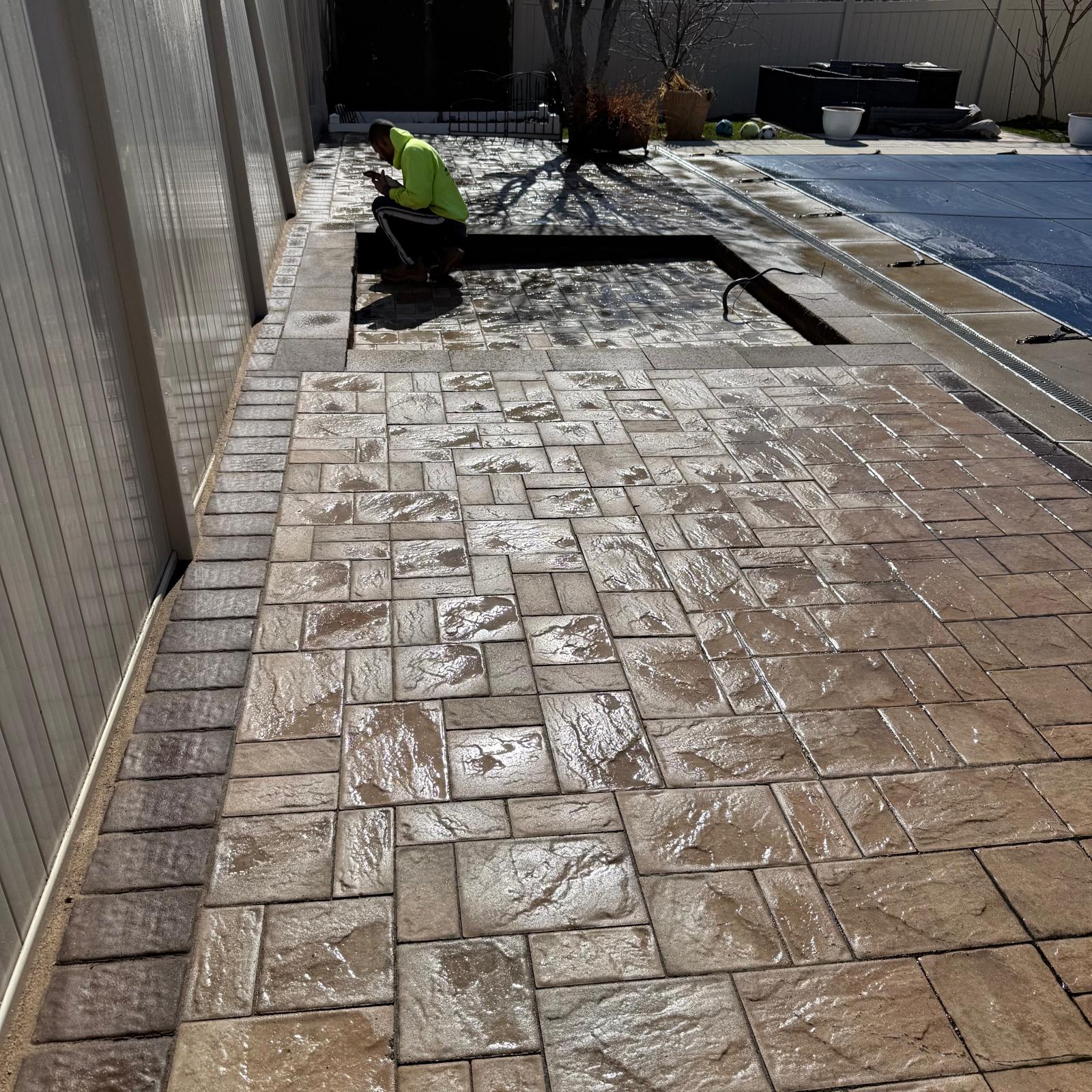 Paver pool deck installation in progress by the IAC crew