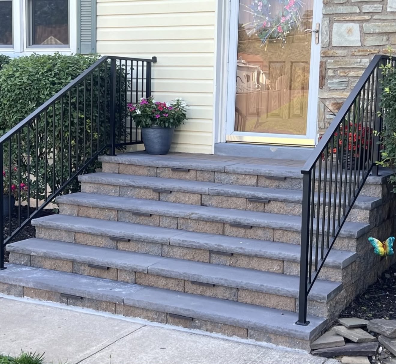 Stone front entry steps with aluminum railing and step lighting
