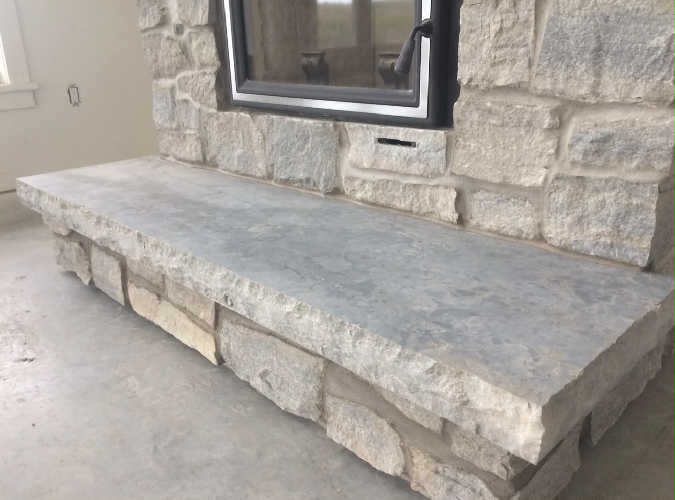 Stone veneer wall with a bluestone hearth